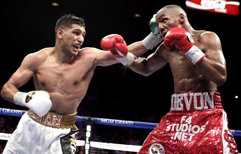 Amir Khan of UK (L) slams a left to the head of Devon Alexander of USA during their WBC Silver Welterweight bout at the MGM Grand Garden Arena on December 13, 2014 in Las Vegas, Nevada. Khan won by unanimous decision. AFP PHOTO/John GURZINSKI